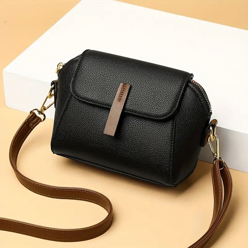 Saffiano flap crossbody bag in black - open interior view showing spacious compartment and inner zip pocket