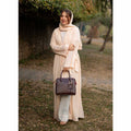 Maroon structured top handle handbag - close-up of side zip pocket with rose gold zip puller