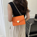 Chevron heart-lock chain crossbody bag in orange - model wearing as crossbody from back view