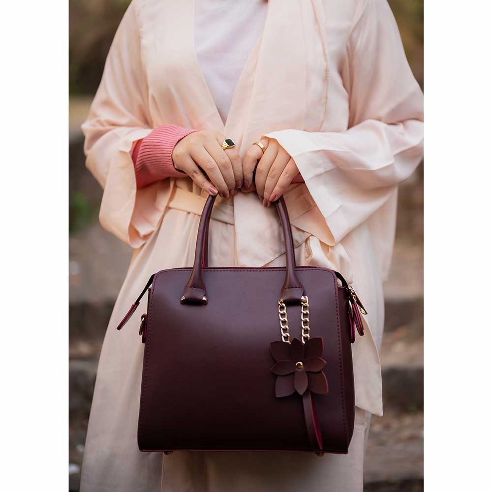 Maroon structured top handle handbag - bottom view showing gold ball studs on base
