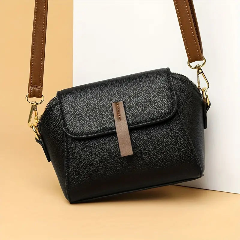 Saffiano flap crossbody bag in black - product bottom view showing gold ball studs on white background