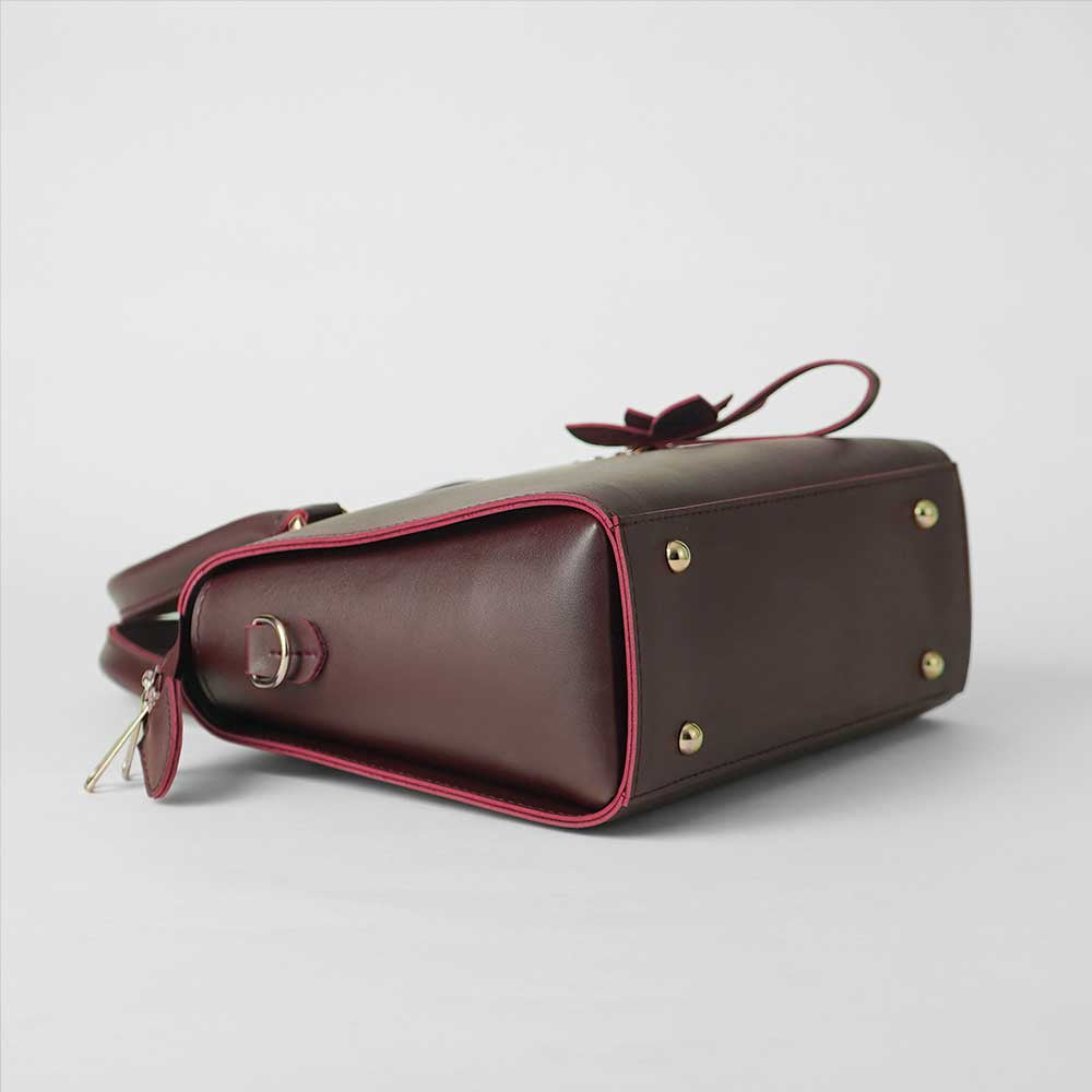 Maroon structured top handle handbag - front product view on white background with crossbody strap