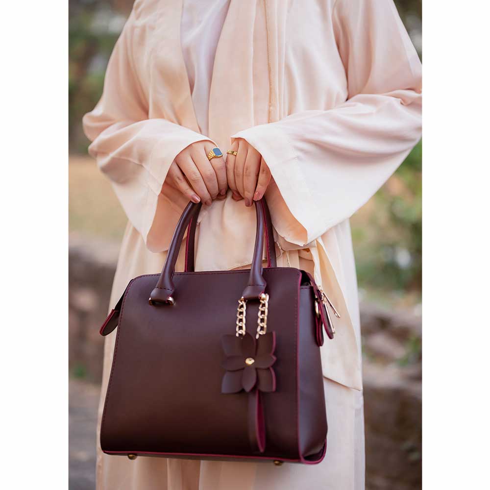 Maroon structured top handle handbag - top-down flat lay view on white surface