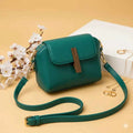 Cavelle crossbody purse in green - angle view with strap