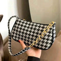 Chic houndstooth shoulder bag - model carrying by top handle with trench coat