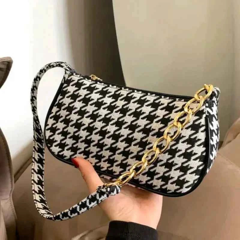 Chic houndstooth shoulder bag - model carrying by top handle with trench coat