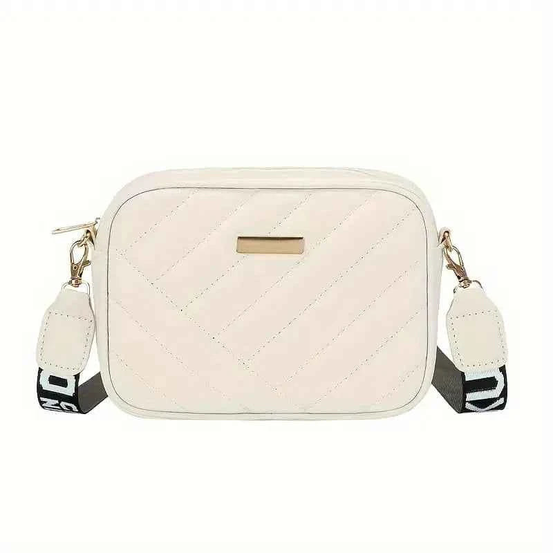 Elorina luxe crossbody bag in tan/brown - lifestyle front view with flowers