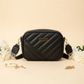 Elorina luxe crossbody bag in maroon - lifestyle front view with flowers