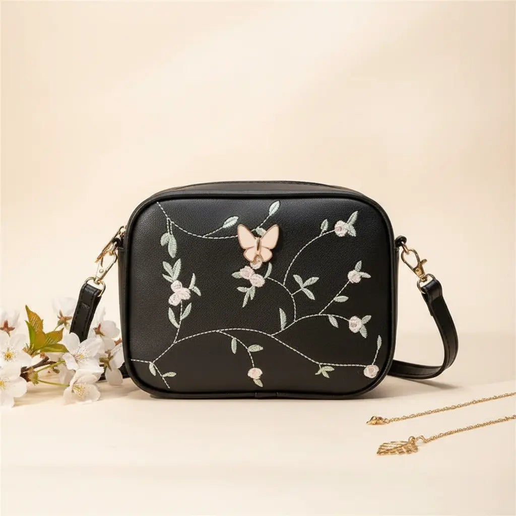 Embroidered butterfly crossbody bag in black - model lifestyle side view