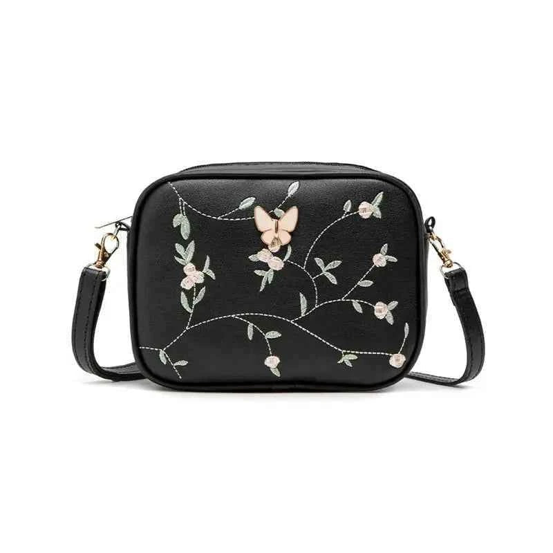Embroidered butterfly crossbody bag in white - top angle view on white surface