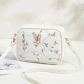 Embroidered butterfly crossbody bag in white - front view on white surface