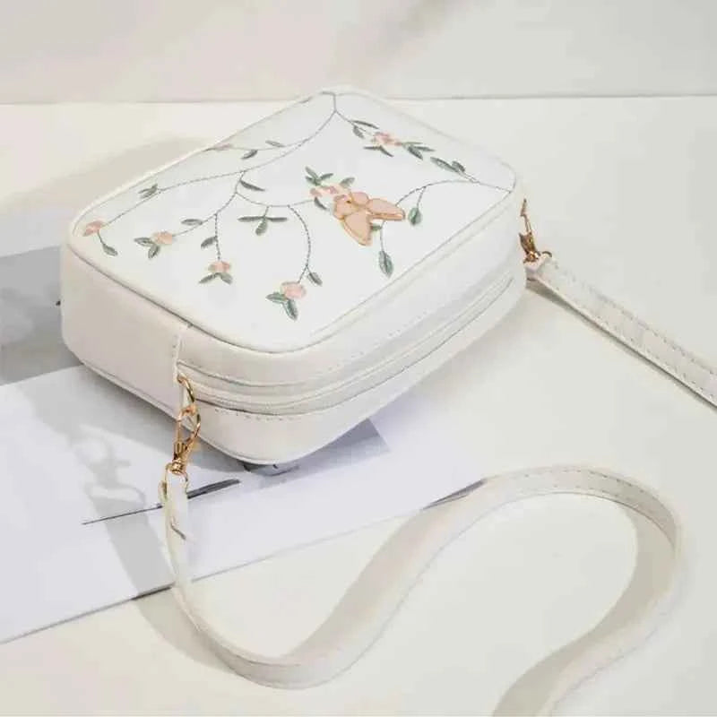 Embroidered butterfly crossbody bag in pink - front view angle 2
