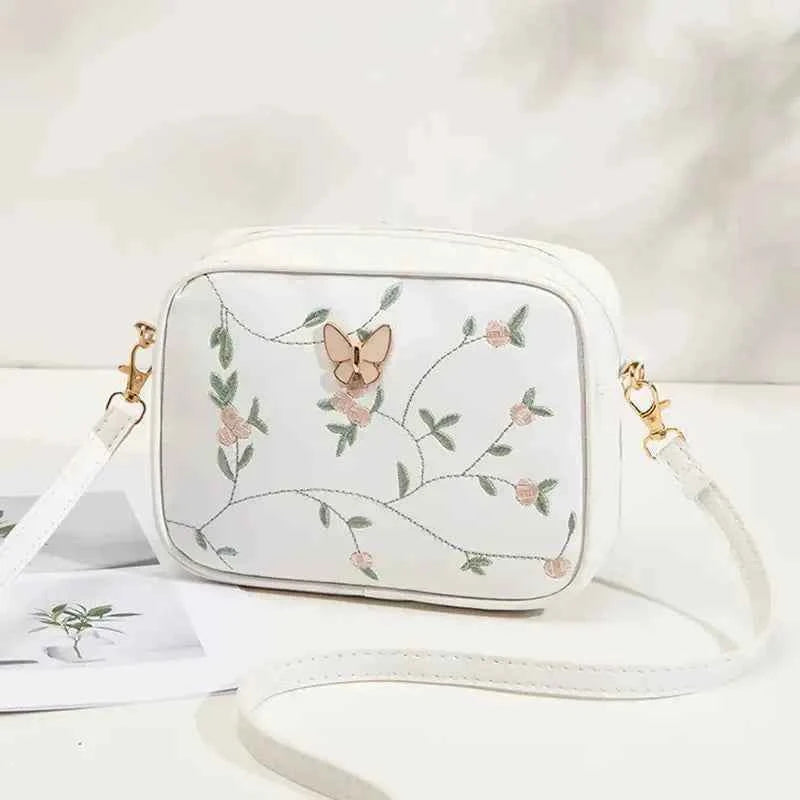 Embroidered butterfly crossbody bag in white - clean front view