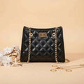 Laila mini chain satchel in black - lifestyle front view with flowers and gold rings