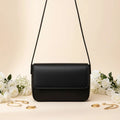 Magnetic crossbody bag in black - clean product front view on white background