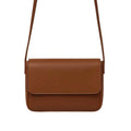 Magnetic crossbody bag in brown/tan - lifestyle side angle view with flowers and gold accessories