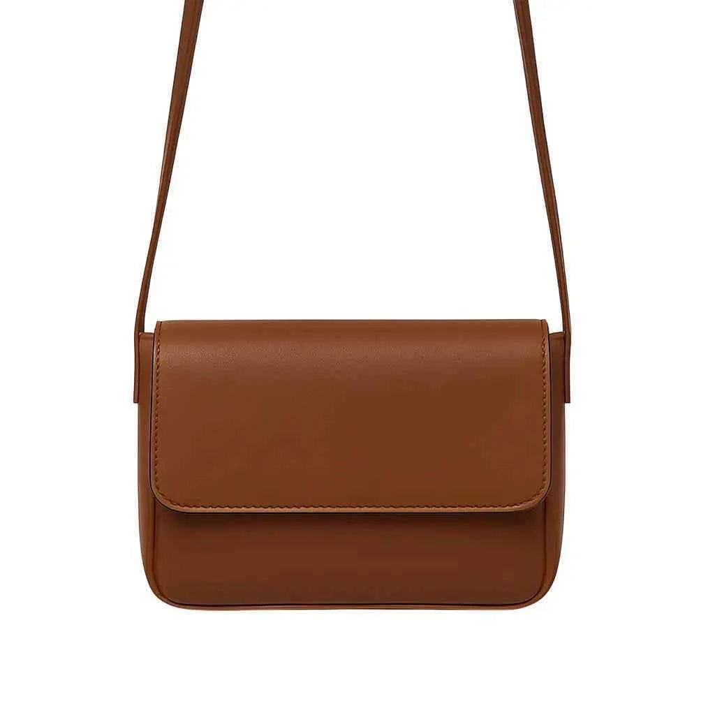 Magnetic crossbody bag in brown/tan - lifestyle side angle view with flowers and gold accessories