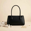 Mahveen elegant ladies handbag in black - front view with white flowers and gold accessories