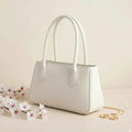 Mahveen elegant ladies handbag in white - side angle view with pink flowers and gold accessories